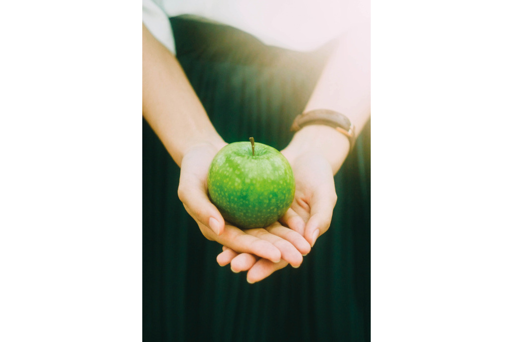 Green apple held in hands